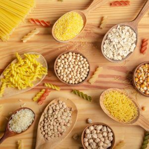 Flat lay Food background made of legumes cereals pasta and grains in wooden spoons on kitchen table