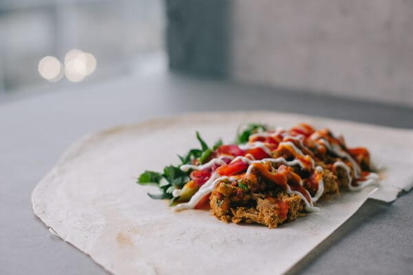 Shawarma preparation. Meat, vegetables and sauce on pita bread.